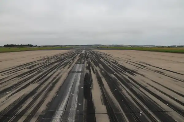 An airport runway showing heavy rubber tyre deposits in the touchdown zone, highlighting the need for PJB's professional friction testing services to assess surface grip and maintain airfield safety.